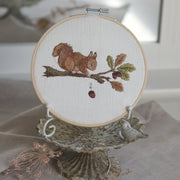 Stickdatei Eichhörnchen mit Haselnuss, Stickmotiv 13x18 cm, Eichhörnchen auf einem Ast mit Blättern