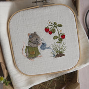 Stickdatei Maus mit Gießkanne im Erdbeergarten. Kleine Maus gießt eine Erdbeerpflanze mit roten Erdbeeren. Maschinenstickerei aus der Erdbeermäuse Serie.